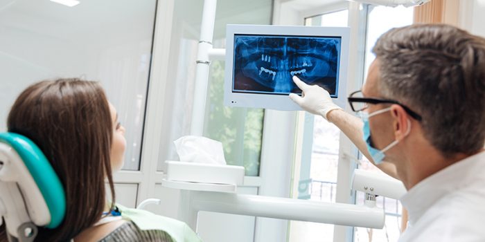 dentist pointing out signs of a cavity on dental x-ray